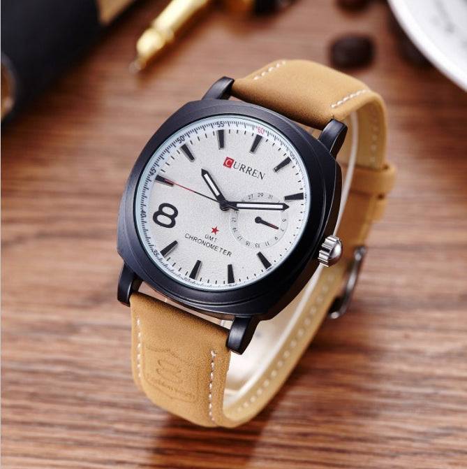 White dial luxury watch with tan strap on wooden surface